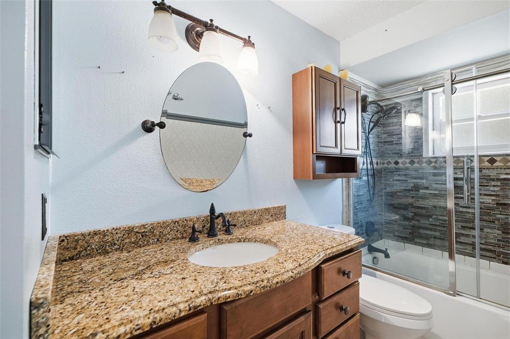 1071 Angora Street Deltona, FL 32725 - Photo 30 of 45 a bathroom with a granite countertop sink toilet and shower