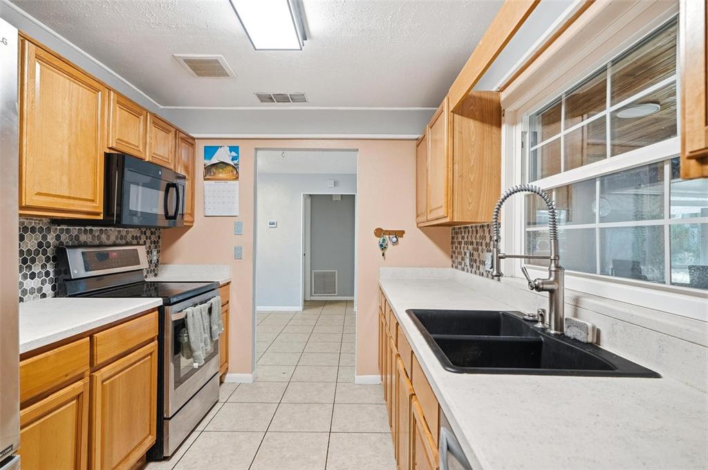 1071 Angora Street Deltona, FL 32725 - Photo 5 of 45 a kitchen with granite countertop a sink and a stove top oven
