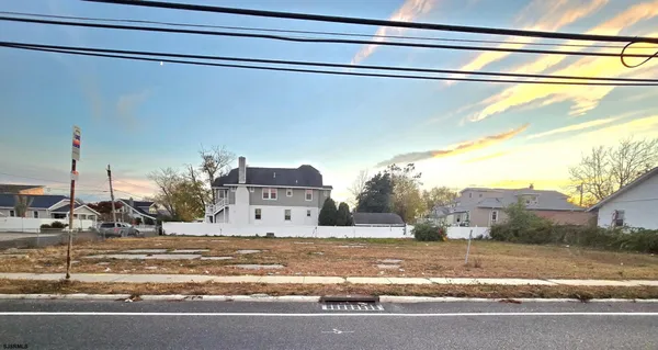 a view of a house with a yard and a street