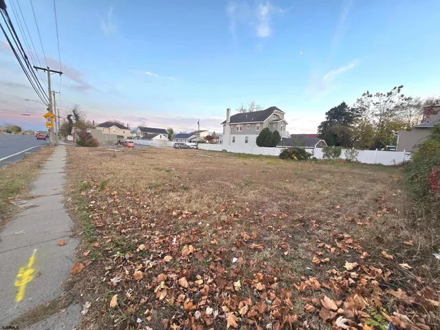 a view of a dry yard with wooden fence