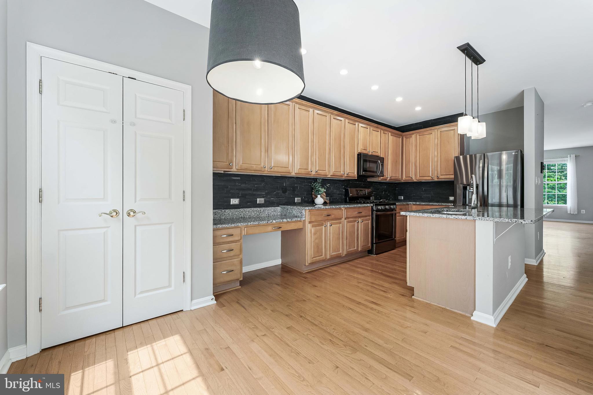 43103 Forest Edge Square Broadlands, VA 20148 - Photo 12 of 57 a kitchen with stainless steel appliances granite countertop a stove a sink and a refrigerator