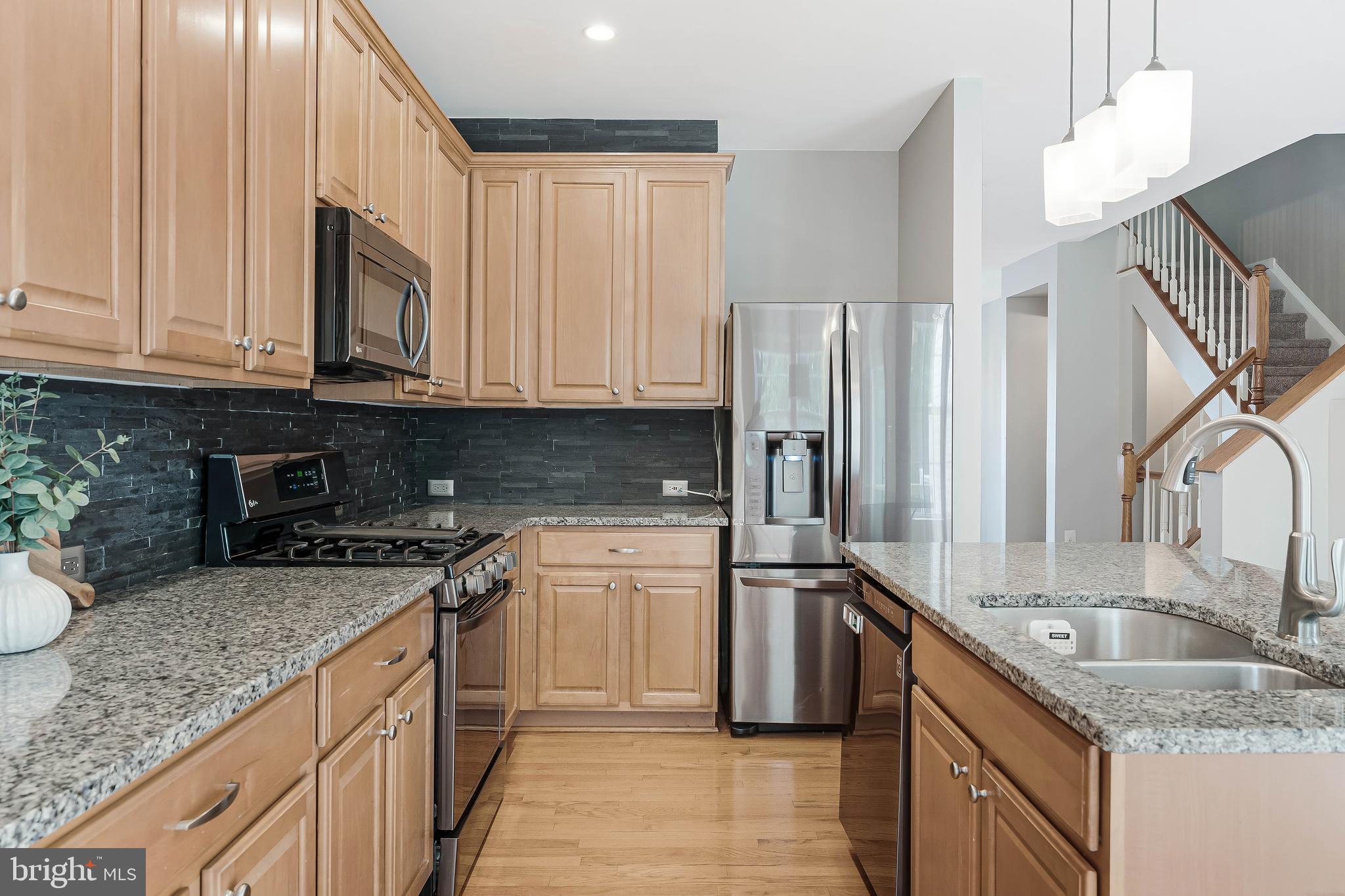 43103 Forest Edge Square Broadlands, VA 20148 - Photo 15 of 57 a kitchen with stainless steel appliances granite countertop a sink stove and refrigerator