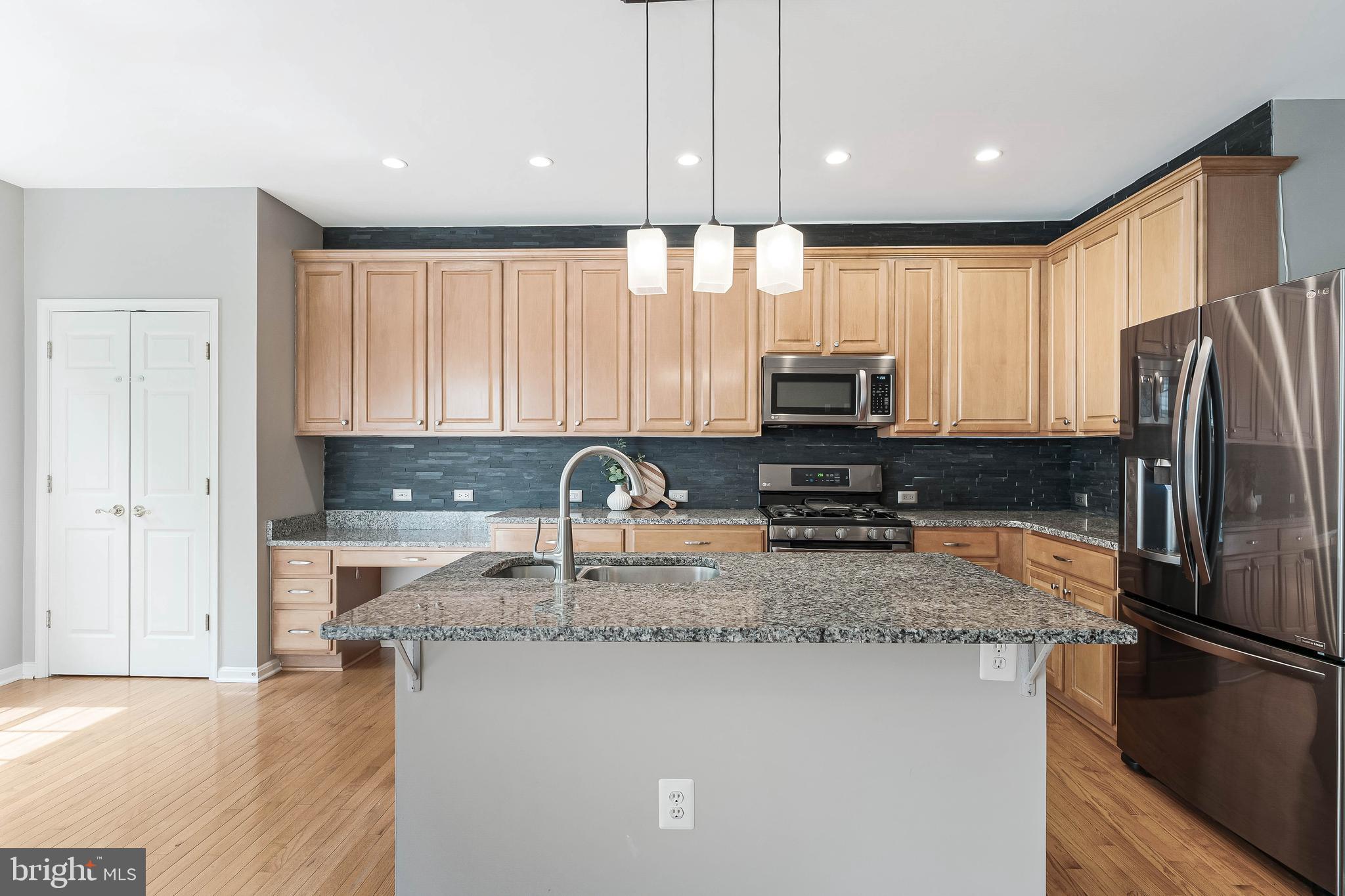 43103 Forest Edge Square Broadlands, VA 20148 - Photo 19 of 57 a kitchen with stainless steel appliances granite countertop a refrigerator a stove top oven a sink and dishwasher