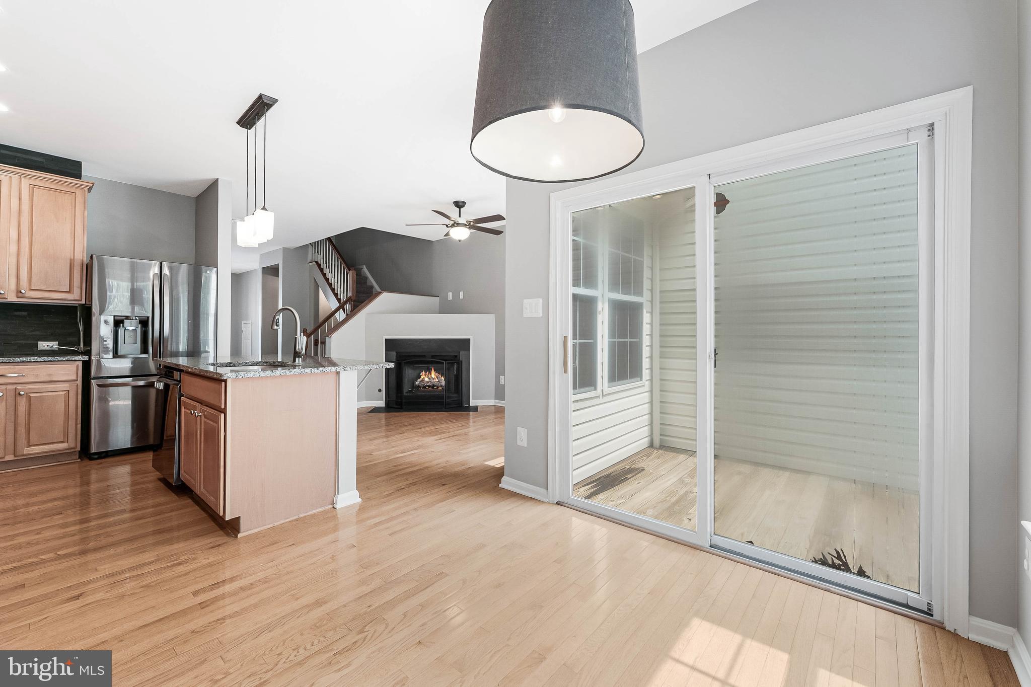 43103 Forest Edge Square Broadlands, VA 20148 - Photo 21 of 57 a kitchen with kitchen island a stove a refrigerator and a fireplace