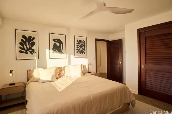 a bedroom with a bed and a painting on the wall