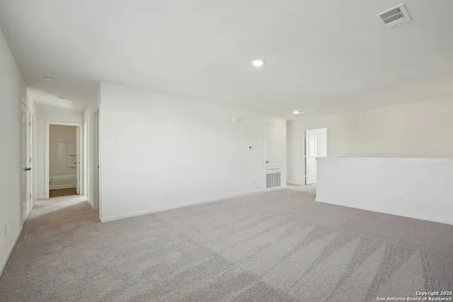 a view of an empty room with closet and a window