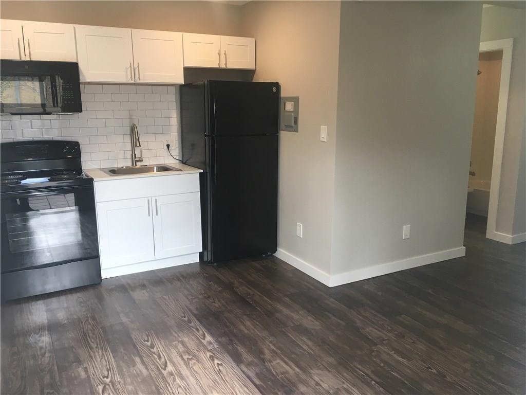 225 West N Loop Boulevard, Unit 201 Austin, TX 78751 - Photo 2 of 6 a kitchen with granite countertop a refrigerator and a stove top oven