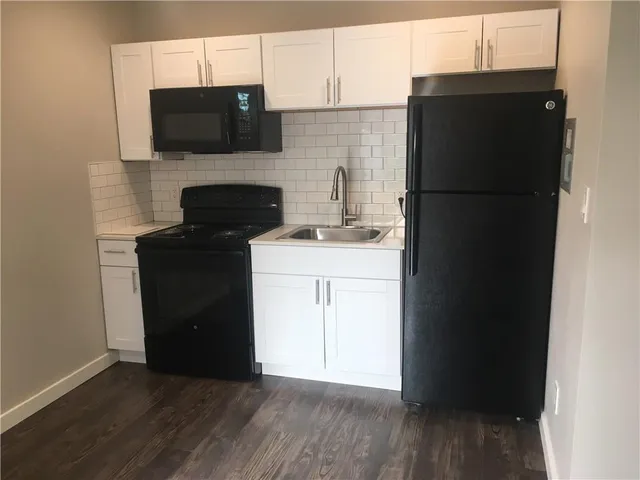 a kitchen with a sink a refrigerator and a microwave