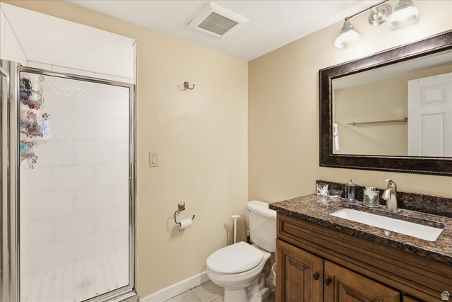 1334 Ridgewood Lane Bountiful, UT 84010 - Photo 31 of 38 Shower with frosted glass enclosure, single vanity with brown cabinetry, countertop with integrated white sink, framed mirror, and wall-mounted light fixture