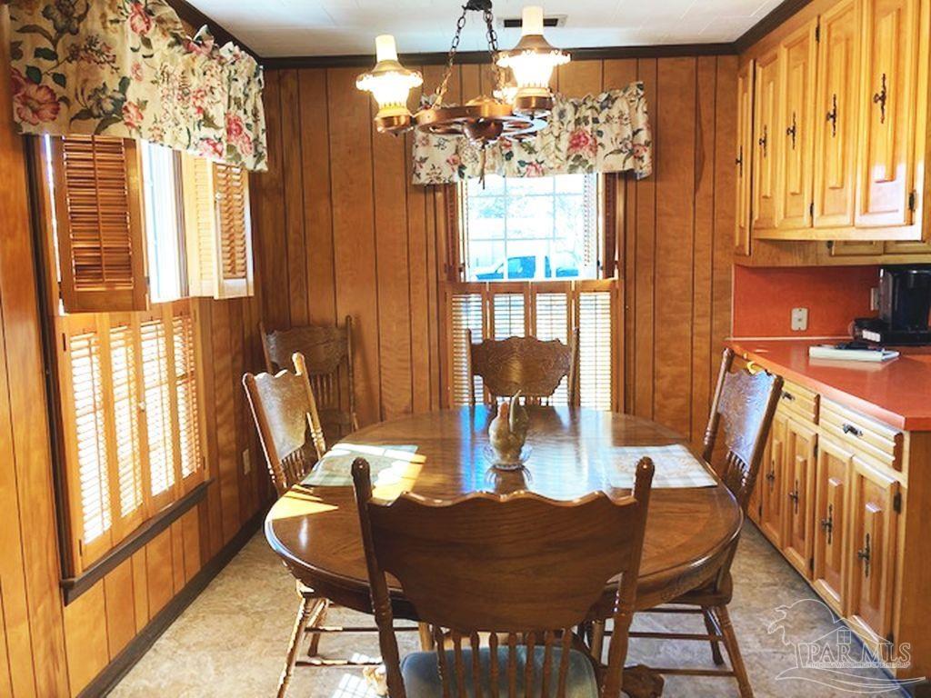 9870 Highway 31 Atmore, AL 36502 - Photo 11 of 31 a view of a dining room with furniture a chandelier and wooden floor