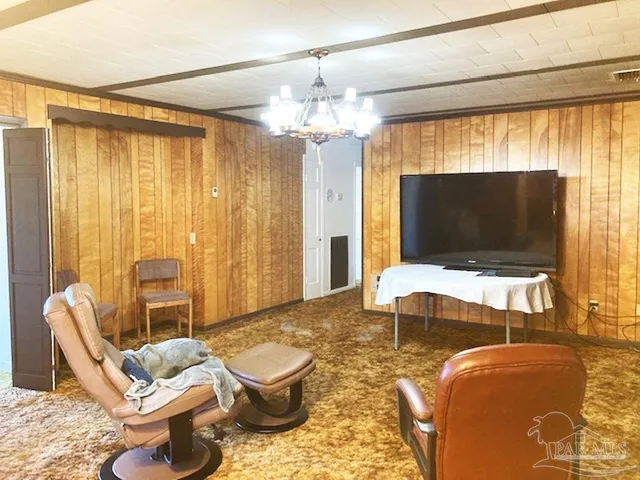 a living room with furniture a flat screen tv and a large window
