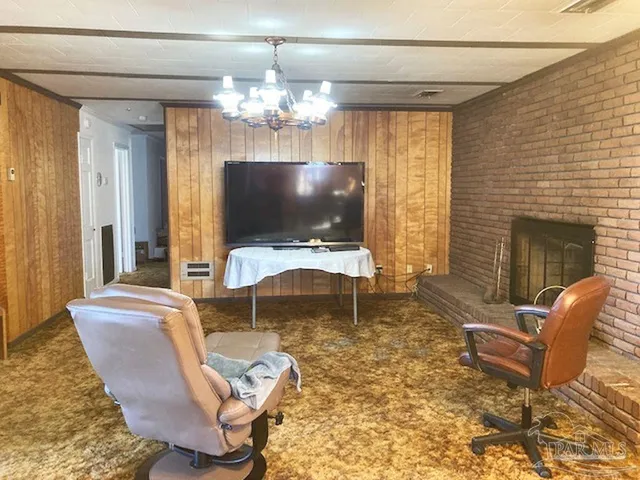 a living room with furniture a fireplace and a chandelier