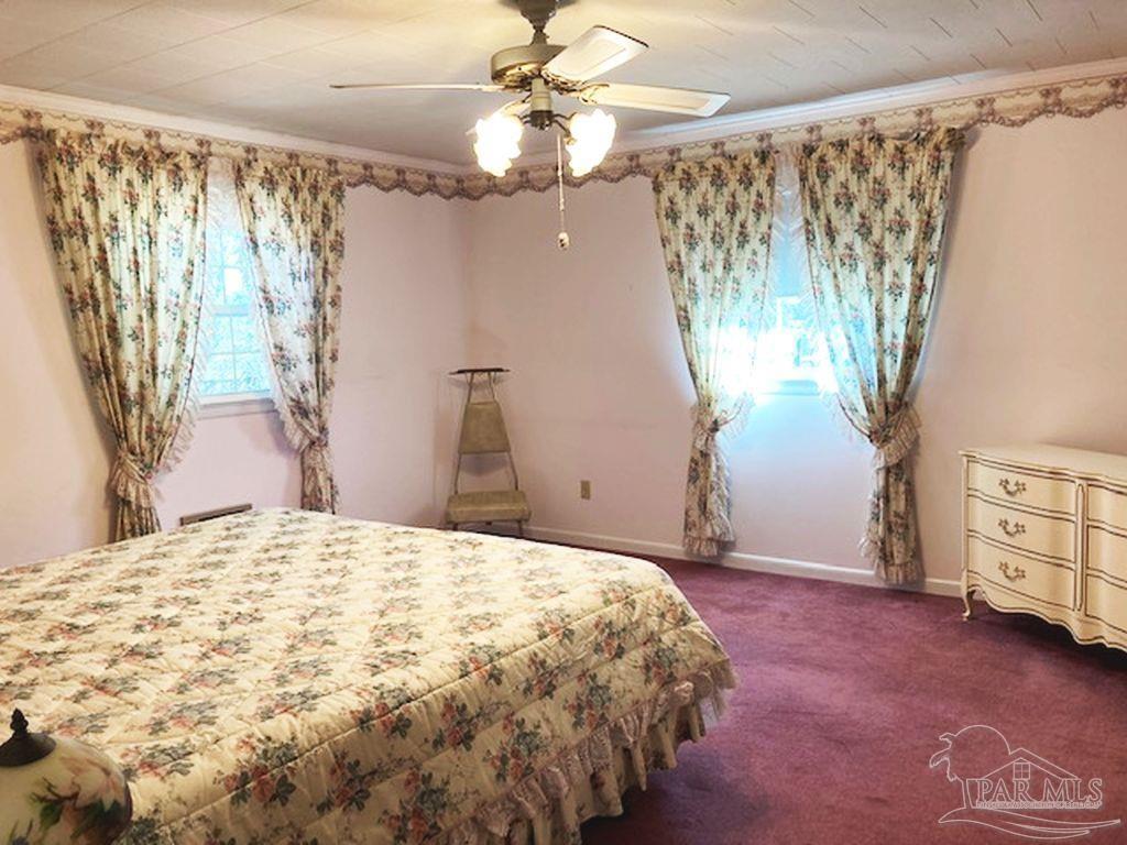 9870 Highway 31 Atmore, AL 36502 - Photo 16 of 31 a bedroom with a bed and a chandelier