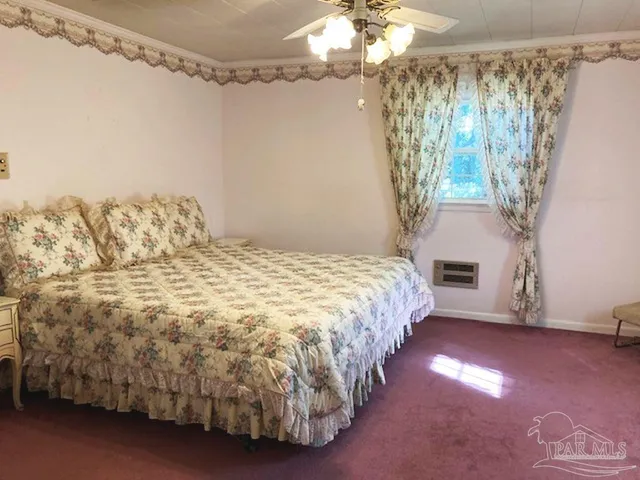 a spacious bedroom with a bed and a chandelier