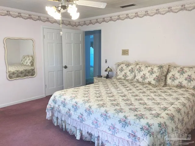 a bedroom with a large bed and a chandelier