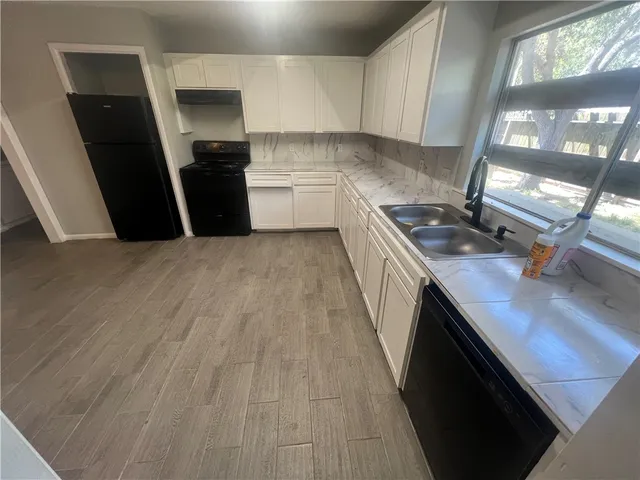 a kitchen with a sink a refrigerator and window