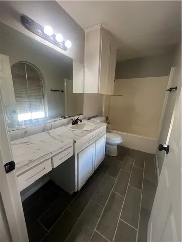 a bathroom with a sink a toilet and mirror