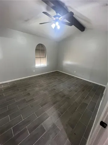en empty room with ceiling fan and window