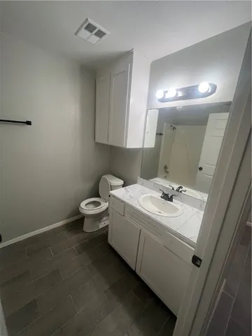 a bathroom with a sink mirror and toilet