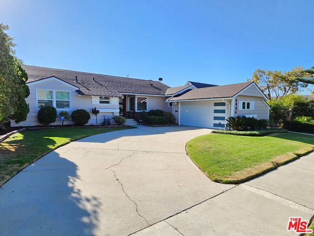 a front view of a house with a garden and yard