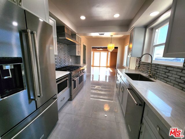 a kitchen with stainless steel appliances a sink stove and refrigerator