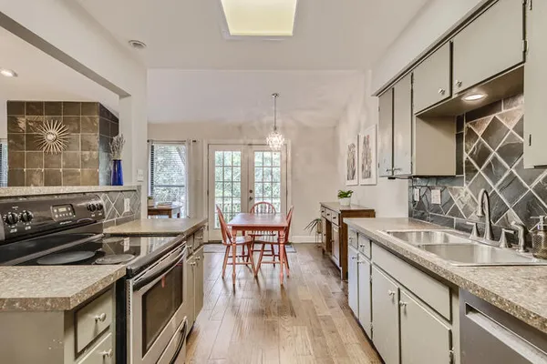 a kitchen with stainless steel appliances granite countertop a sink stove and refrigerator