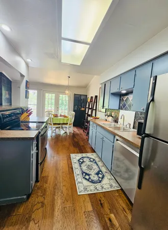 a kitchen with stainless steel appliances granite countertop a refrigerator stove oven and a sink