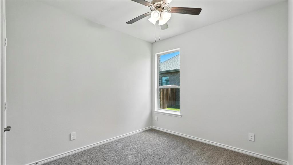 4191 Waldron Trail Forney, TX 75126 - Photo 18 of 20 Bedroom featuring light gray wall paint, gray carpeting, a single window with white trim, and a ceiling fan with integrated lighting