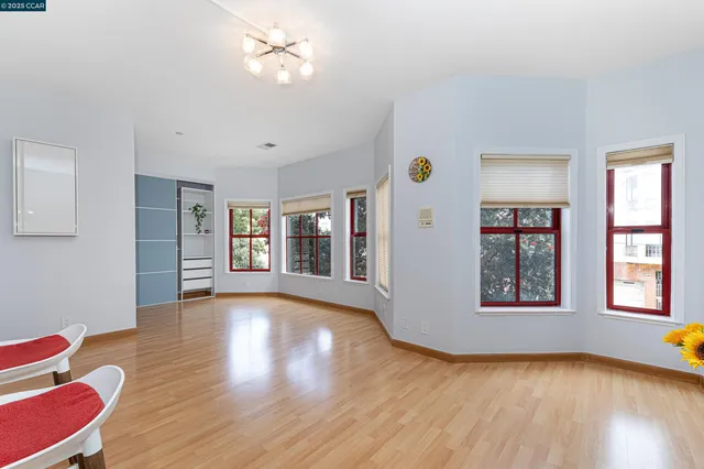 a view of an empty room with window and wooden floor