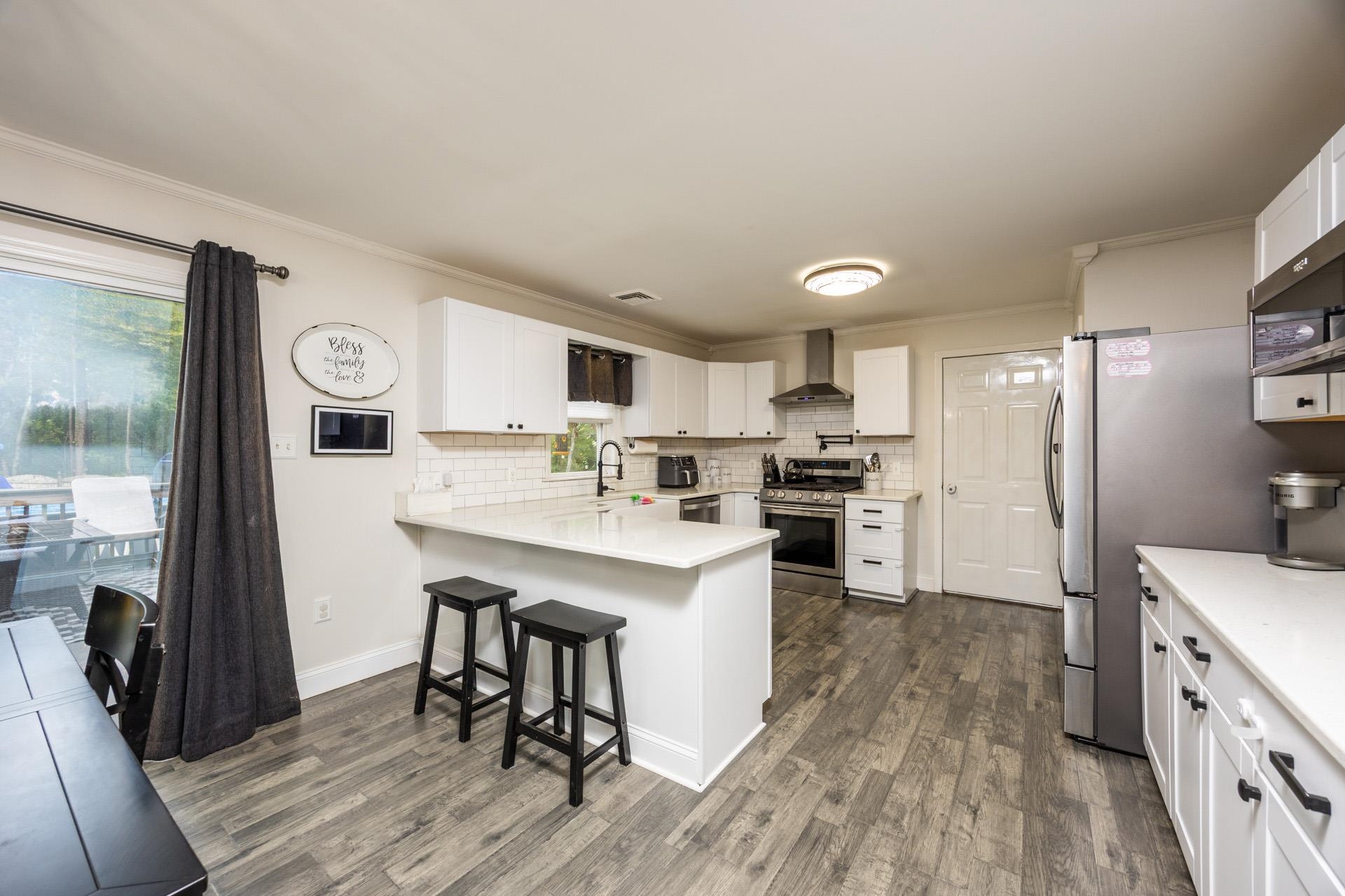 405 Old Goshen Road Ocean View, NJ 08230 - Photo 11 of 38 a kitchen with stainless steel appliances granite countertop a refrigerator a stove a sink dishwasher and white cabinets with wooden floor