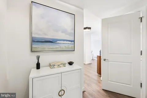 a hallway with view of wooden floor and mirror