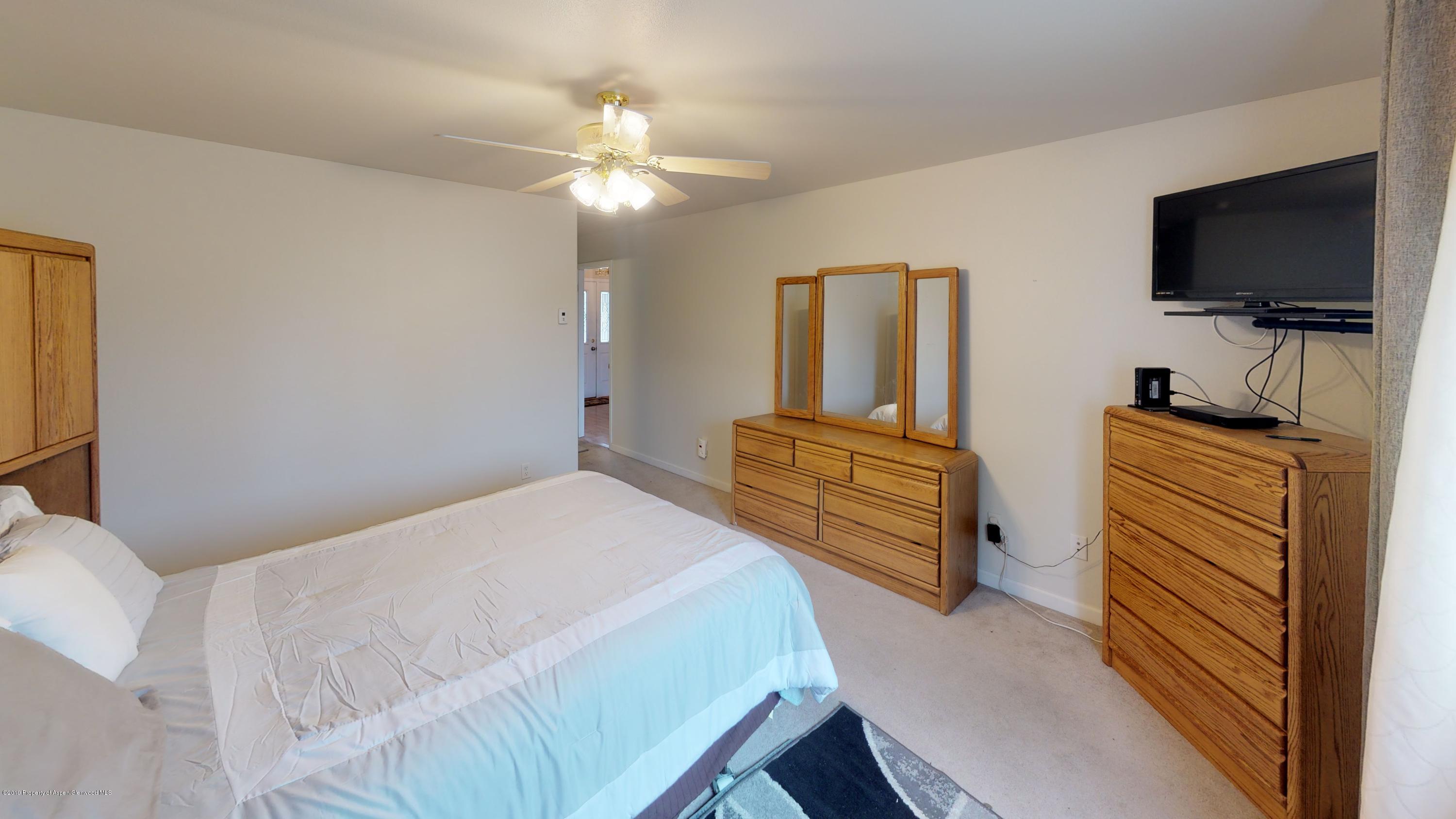 1293 Fir Avenue Rifle, CO 81650 - Photo 28 of 49 a bedroom with a bed and a flat screen tv