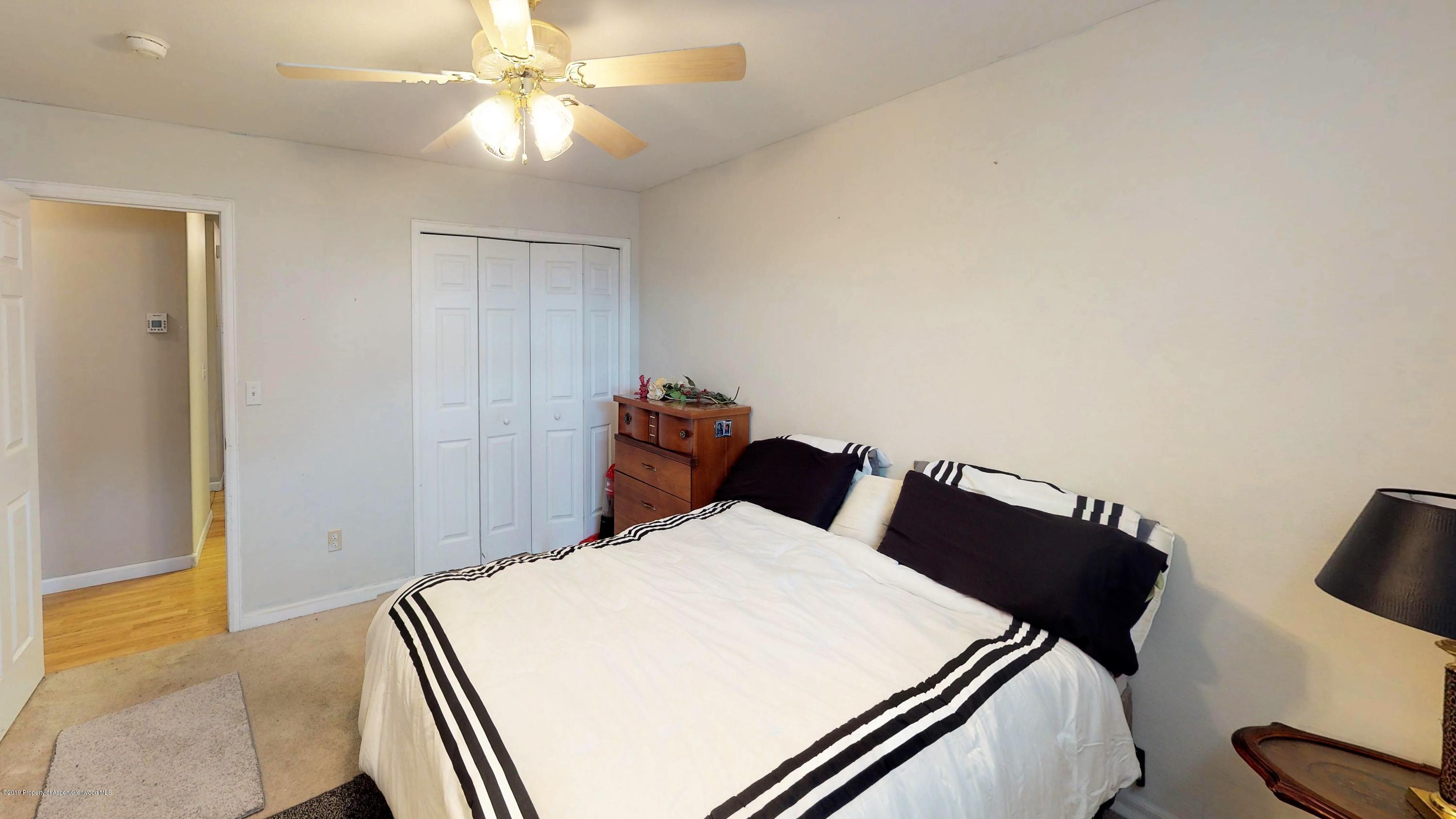 1293 Fir Avenue Rifle, CO 81650 - Photo 7 of 49 a bed room with a bed and a chandelier