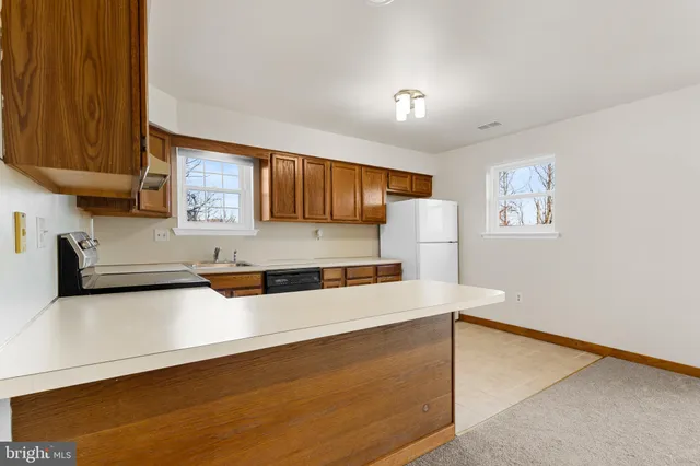 a kitchen with granite countertop a refrigerator and a stove top oven