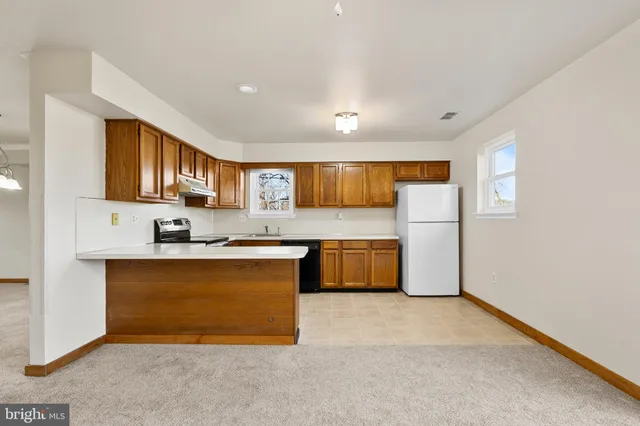 a large kitchen with stainless steel appliances granite countertop a stove a sink dishwasher and a refrigerator