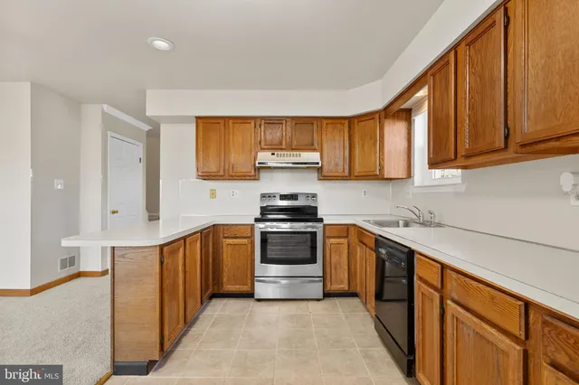 a kitchen with stainless steel appliances granite countertop a stove a sink and a refrigerator