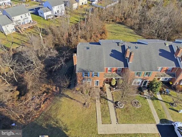 an aerial view of a house with swimming pool and large trees