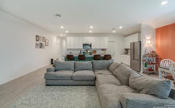 a living room with furniture and a refrigerator