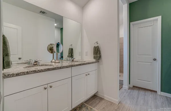 a bathroom with a granite countertop sink and a mirror