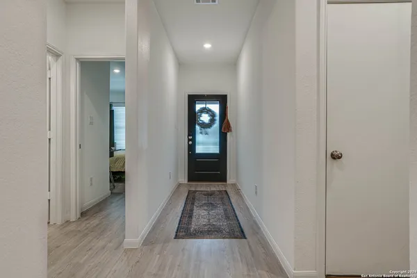 a view of a hallway with wooden floor and staircase