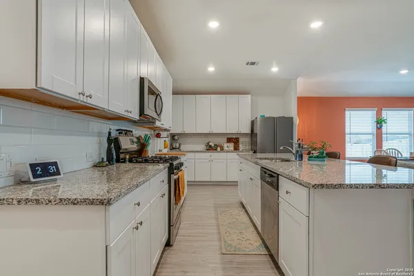 a kitchen with stainless steel appliances granite countertop wooden cabinets a sink and a stove