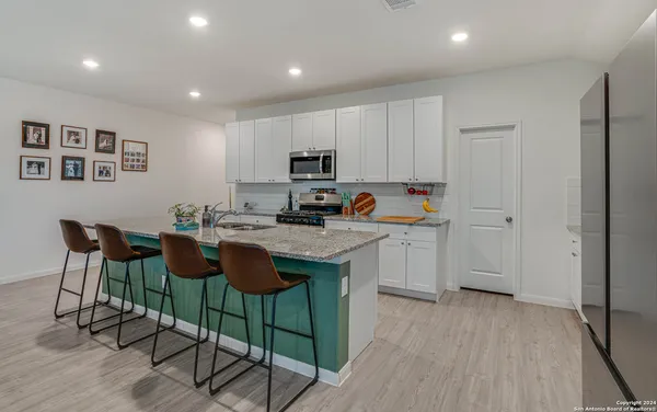 a kitchen with granite countertop a sink cabinets and wooden floor