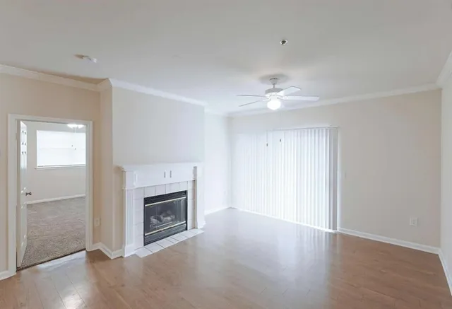 a view of an empty room with a fireplace and a window