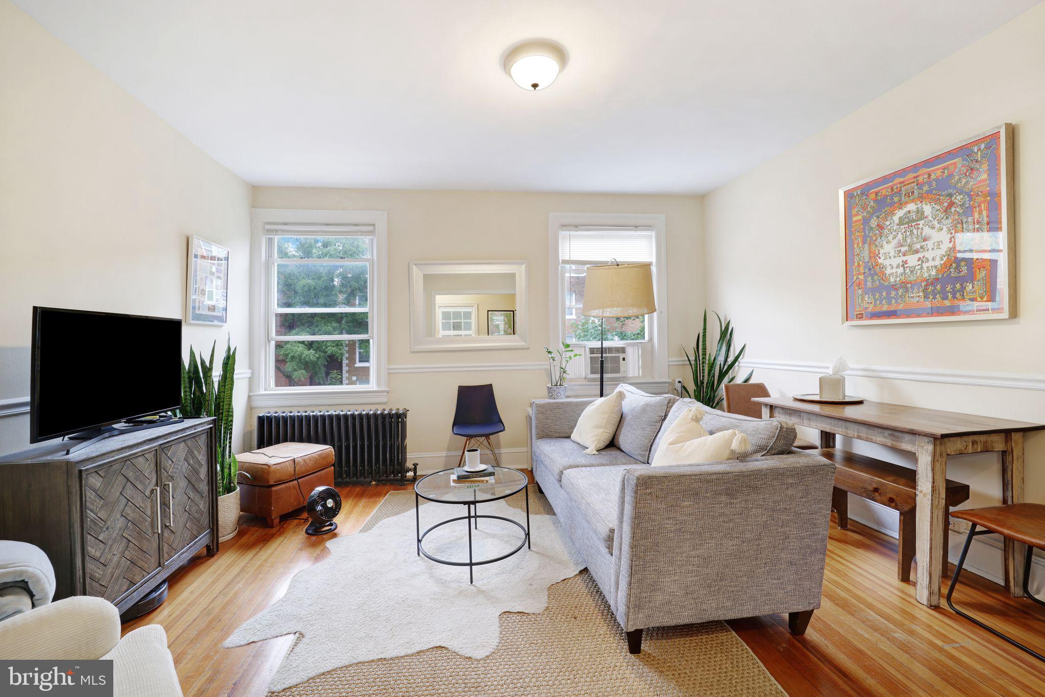 1426 12th Street Northwest, Unit 5 Washington, DC 20005 - Photo 2 of 21 a living room with furniture a flat screen tv and a large window