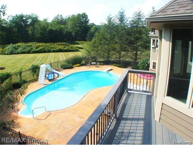 8629 Sashabaw Road Clarkston, MI 48348 - Photo 27 of 34 Balcony with view of pool/patio area and property backing to 1200+ acres of Independence Oaks park with paved bike trails, boat rentals, hiking/running trails.