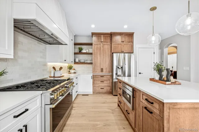 a kitchen with stainless steel appliances a sink stove and cabinets