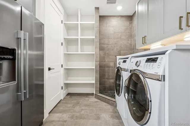 a utility room with cabinets washer and dryer
