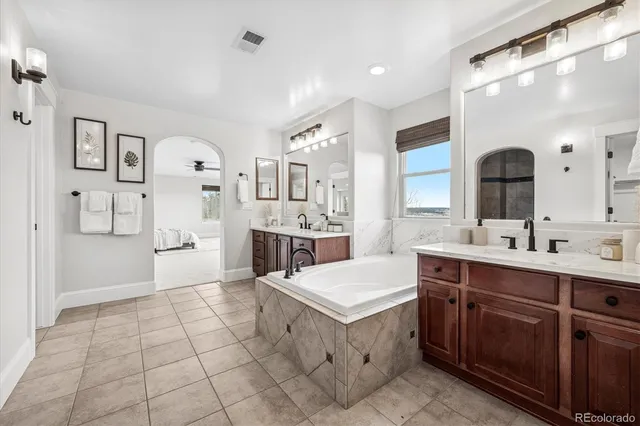 a large white kitchen with a sink a counter top space stainless steel appliances and cabinets