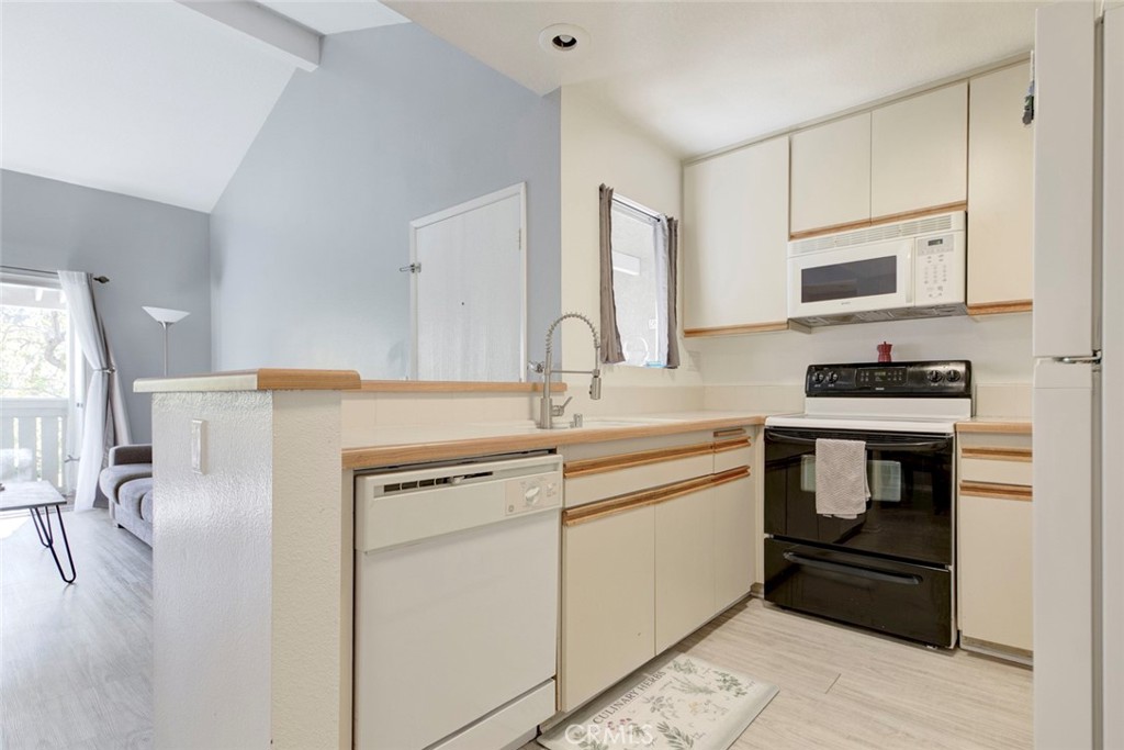 27620 Susan Beth Way, Unit L Saugus, CA 91350 - Photo 11 of 26 a kitchen with a refrigerator and a stove top oven