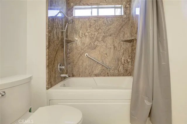 a bathroom with a toilet and a bathtub